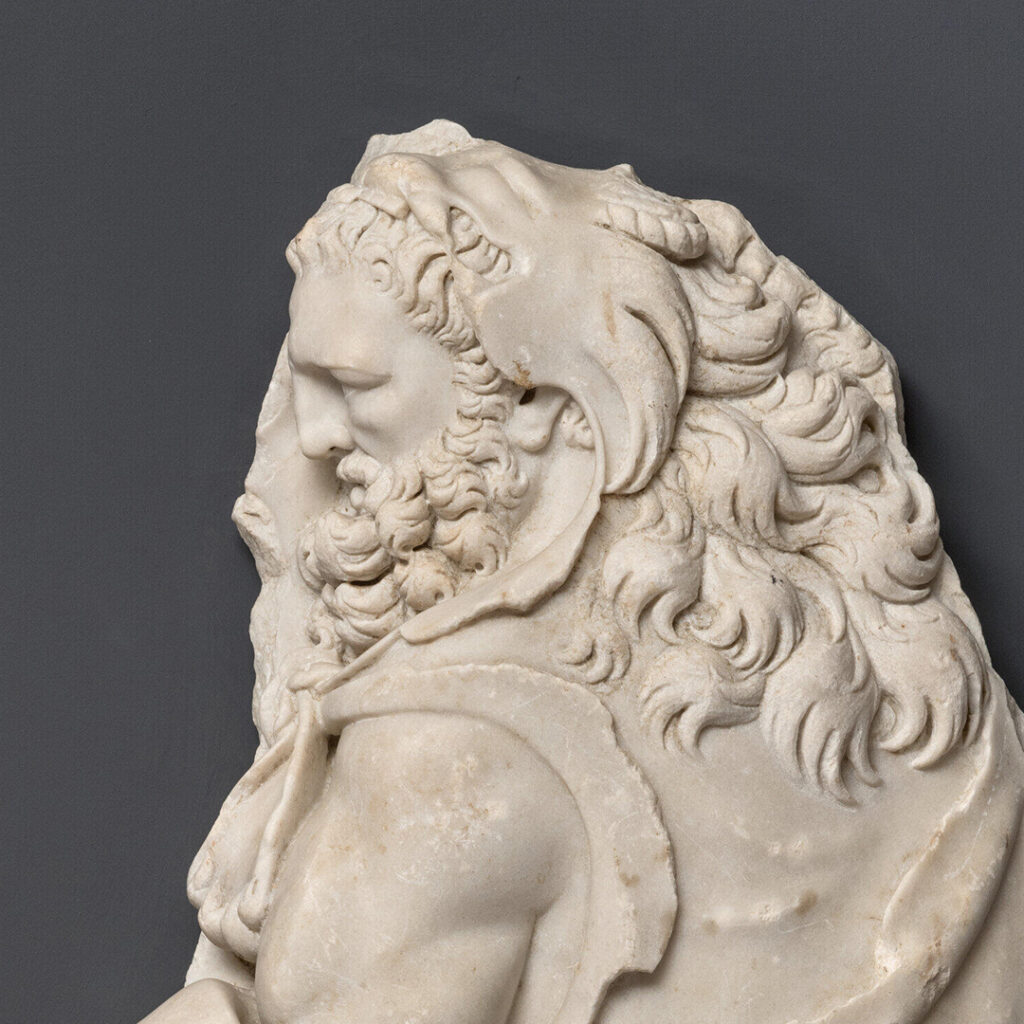 Détail d'un relief sculpté. Hercule, vu de profil. Sa tête est recouverte de la peau du lion de Némée.