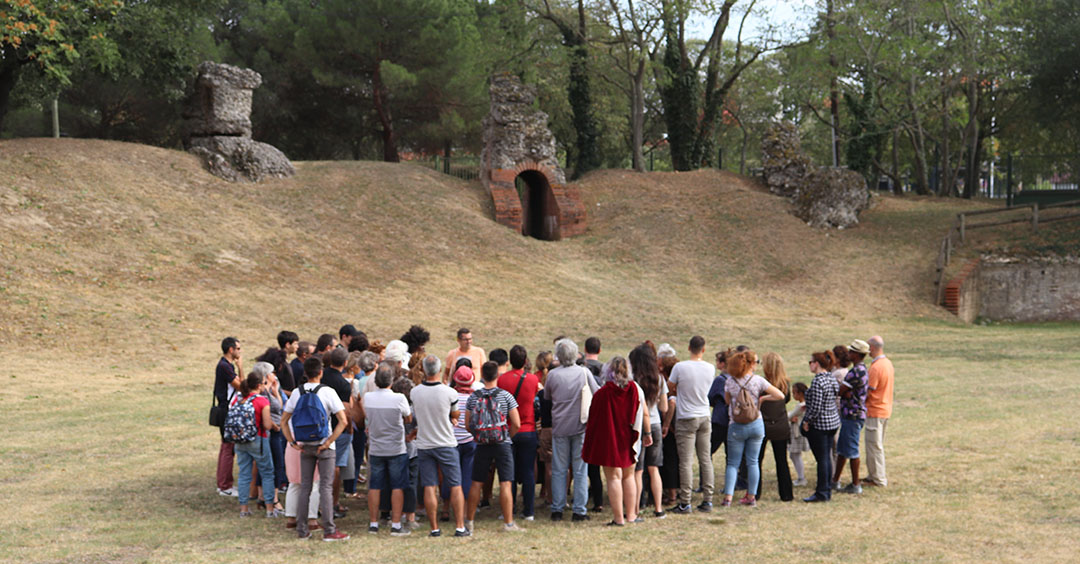 Un groupe assiste à une visite guidée sur le site de l'amphithéâtre romain de Toulouse-Purpan