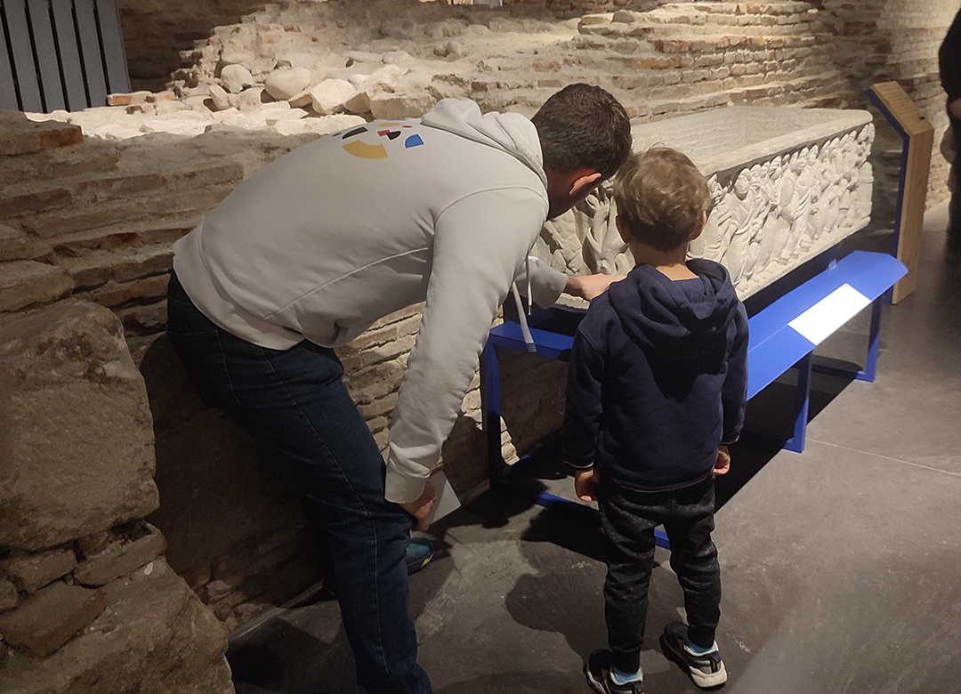 Et un homme et un enfant observent un sarcophage.