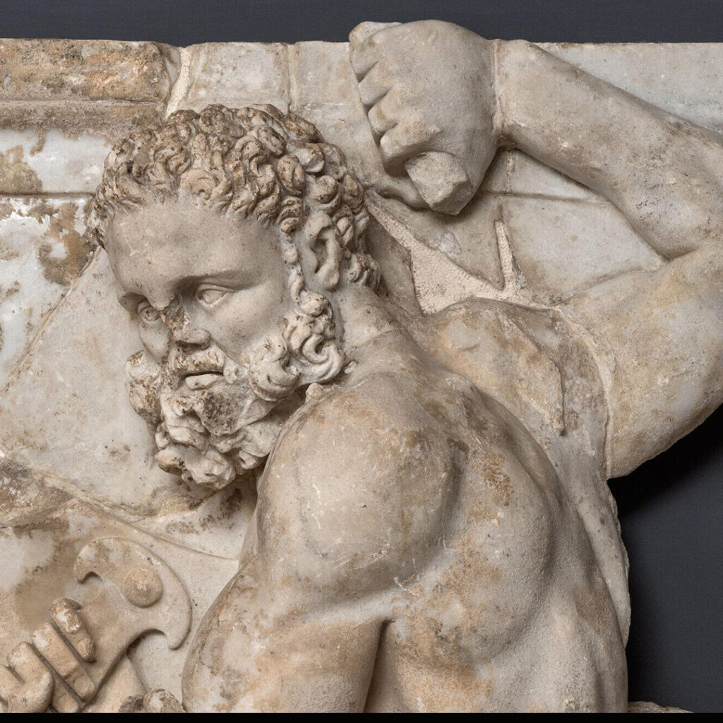 Détail d'un relief sculpté en marbre : Hercule, vu de profil.