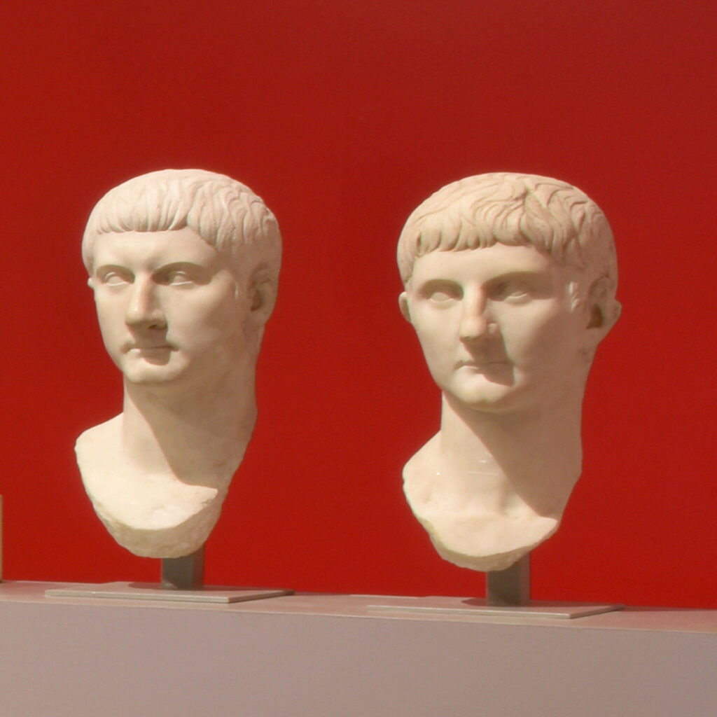 Deux têtes sculptées représentant des hommes.