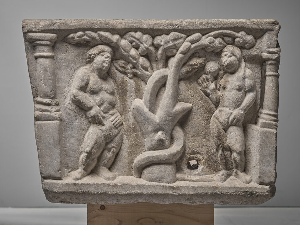 Face latérale gauche de la cuve d'un sarcophage. Au centre un pommier. Un serpent s'enroule autour de son tronc. Sa tête est dirigée vers la droite, vers une femme, nue, qui cueille une pomme. Il s'agit d'Eve. De l'autre côté de l'arbre, se trouve un homme nu : Adam.