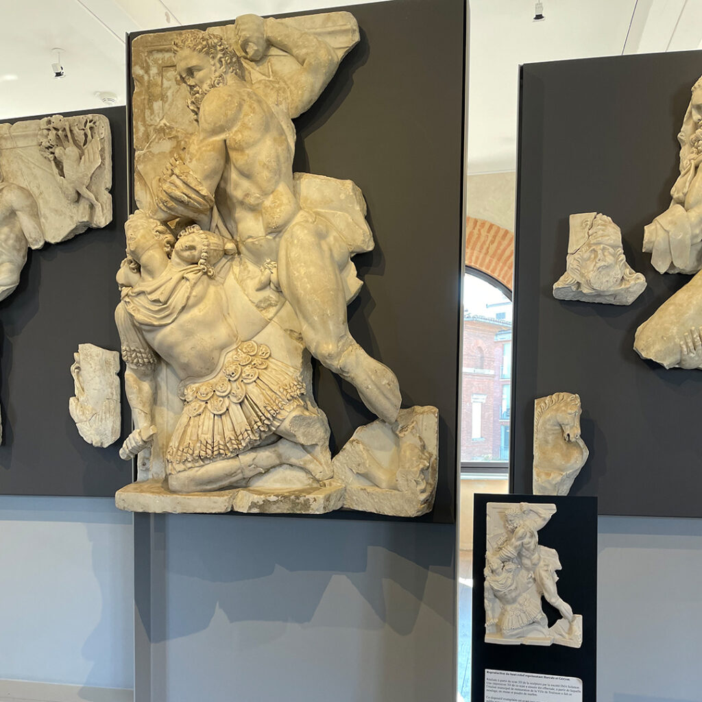 Dispositif tactile placé en avant et à droite du relief sculpté représentant Hercule combattant Géryon.