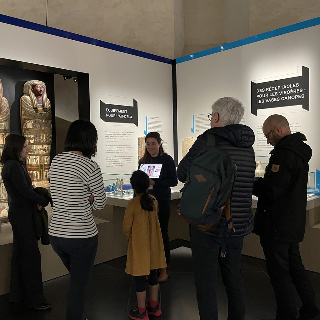 Une médiatrice culturelle fait une visite guidée dans l'exposition Sortie de boîte(s).