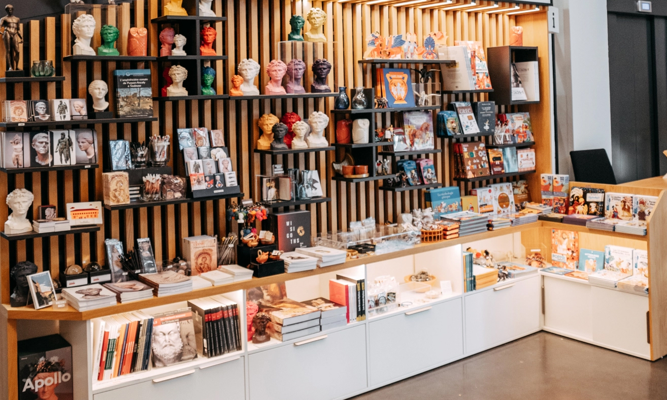 Vue d'une partie de la boutique du musée avec des rayonnages présentant des objets et des livres.