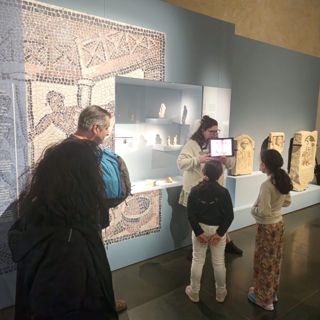Des visiteurs assistent à une visite dans l'exposition "Gaulois mais Romains !"